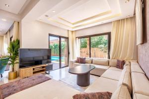 ein Wohnzimmer mit Sofa und Fernseher in der Unterkunft Comfortable villa with heated pool in Marrakesch