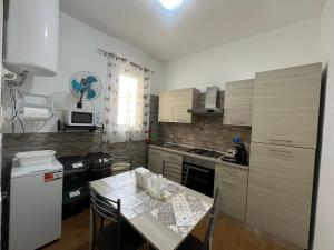 a kitchen with a table with chairs and a white refrigerator at La Petite Maison in Augusta