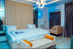 una camera da letto con un grande letto bianco e un divano di Best Terrace Homes a Oshogbo