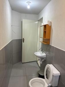 a bathroom with a toilet and a sink at Suítes quintino in Uberlândia