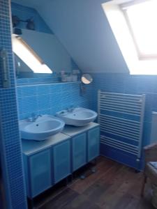 two sinks in a blue bathroom with a skylight at Útulné zátišie v zoborskom dome in Nitra