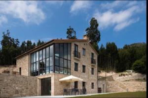 a large stone house with a large window at Villa - 5 Bedrooms with WiFi - 7841 in A Estrada