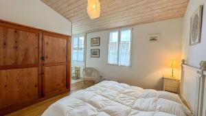 a large bed in a bedroom with a wooden ceiling at Belle maison familiale avec piscine et parking in Loix +8 photos
