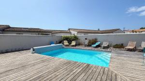 a small swimming pool on a wooden deck at Belle maison familiale avec piscine et parking in Loix