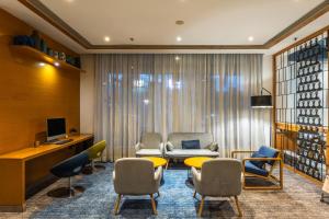 a lobby with a waiting room with chairs and a tv at Holiday Inn Express Chennai OMR Thoraipakkam by IHG in Chennai
