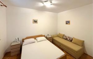 a small bedroom with a bed and a couch at Awesome Apartment In Duce With House Sea View in Duće