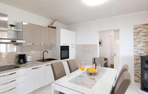 a white kitchen with a table with fruit on it at Amazing Home In Makarska in Veliko Brdo