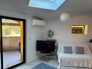 Un dormitorio con una cama y un televisor de pantalla plana. en Kôté Sea Apartment, en Seignosse