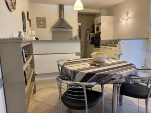 Una cocina con una mesa y sillas en una cocina. en Kôté Sea Apartment, en Seignosse