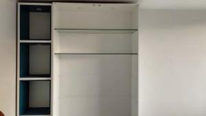 a white cabinet with glass shelves in a room at Hospedaje Aquaman in Hacienda El Recreo