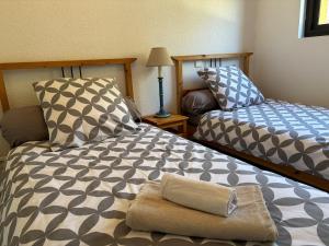 1 dormitorio con 2 camas y almohada en Kôté Sea Apartment, en Seignosse