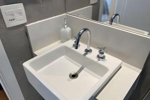 a white sink in a bathroom with a faucet at Geo Berrini Residences in Sao Paulo +84 photos