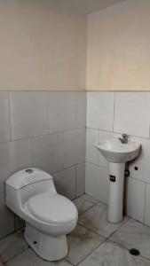 a bathroom with a toilet and a sink at Hospedaje Aquaman in Hacienda El Recreo