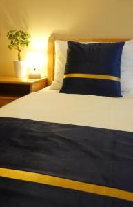 a bed with a blue and white pillow and a plant at Pension Liechtenstein in Vienna