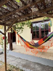 a woman laying in a hammock under a building at Casa Jardim jabuticabas na fronteira in Brasiléia
