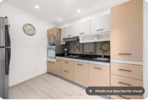 a kitchen with white cabinets and a clock on the wall at Vita House in Quito +13 photos