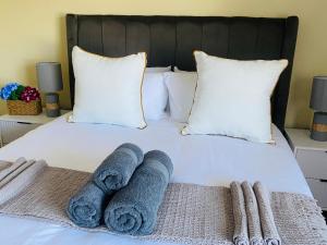 a bed with towels sitting on top of it at PJ Guest House in Gqeberha +15 photos