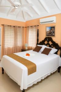 Un dormitorio con una cama grande blanca con ventilador de techo. en Tropical Escape in Richmond with Pool & Gym Perfect Paradise Getaway Sleeps 7 Perfect for Families, en Richmond