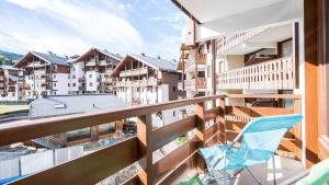a balcony with a chair and some buildings at Les Eterlous N24 2P6 in Morillon