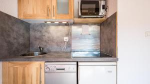 a small kitchen with a sink and a microwave at Les Eterlous N24 2P6 in Morillon +3 photos