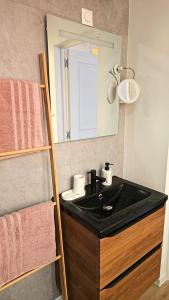 a bathroom with a black sink and a mirror at Appartement lumineux 50M2 proche mer-centre Portel in Le Portel