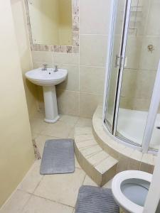 a bathroom with a toilet and a sink and a shower at PJ Guest House in Gqeberha