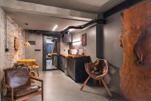 a room with two chairs and a kitchen with a counter at Glam Taoo Hotel Apartamento Boutique in Lugo