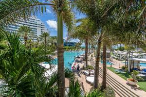 an aerial view of a resort pool with palm trees at Fontaine Bleau Suite - Street & Partial Ocean view in Miami Beach