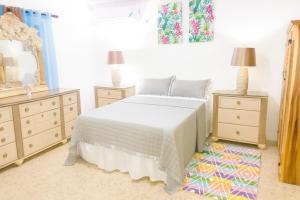 Chantal House Sleeps 8 with Garden في Buff Bay: غرفة نوم بها سرير وسريرين ومرآة