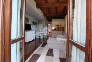 Una sala de estar con un sofá y una cocina. en Appartamento La Dimora Del Lupo, en Morlupo