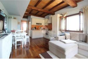 Una sala de estar con un sofá blanco y una cocina. en Appartamento La Dimora Del Lupo, en Morlupo