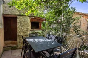 einen Tisch und Stühle auf dem Balkon eines Hauses in der Unterkunft La maison du château in Fontaine-de-Vaucluse