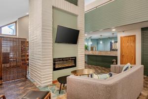 a living room with a couch and a fireplace at MainStay Suites Springfield South - Battlefield Rd in Springfield