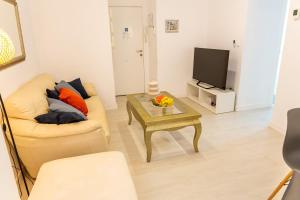 a living room with a couch and a table and a tv at Canasteros Apartments ! in Málaga