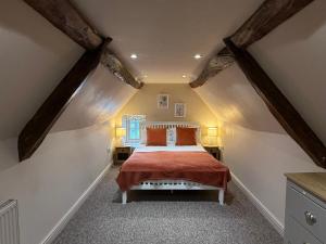 a bedroom with a large bed with orange pillows at Tuckers Grave Inn - Historic Inn & Cider Pub in Norton Saint Philip