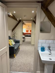 a bathroom with a sink and a couch in a room at Tuckers Grave Inn - Historic Inn & Cider Pub in Norton Saint Philip