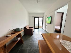 una sala de estar con una mesa y un sofá en A 3 min do Mar e 5 da Feirinha - Guilhermina!, en Praia Grande