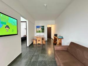 Una sala de estar con un sofá y un televisor de pantalla plana. en A 3 min do Mar e 5 da Feirinha - Guilhermina!, en Praia Grande