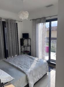 a bedroom with a bed and a large window at T3 Cros De Cagnes Bord De plage in Cagnes-sur-Mer