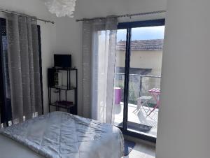 a room with a bed and a sliding glass door at T3 Cros De Cagnes Bord De plage in Cagnes-sur-Mer