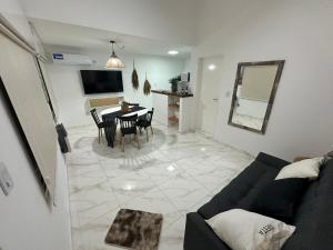 een woonkamer met een bank en een tafel met stoelen bij COMPLEJO JONAS SALK - departamento de 1 dormitorio amoblado in San Francisco