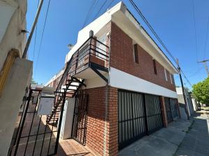 een bakstenen gebouw met een brandtrap aan de zijkant bij COMPLEJO JONAS SALK - departamento de 1 dormitorio amoblado in San Francisco