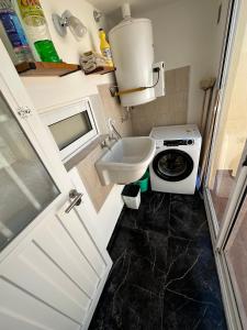 een kleine badkamer met een wastafel en een wasmachine bij COMPLEJO JONAS SALK - departamento de 1 dormitorio amoblado in San Francisco +37 foto's