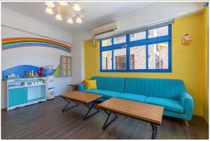 sala de estar con sofá azul y arco iris en White Sand Homestay, en Hualien City