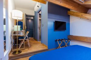 a bedroom with a blue wall with a bed and a table at Palazzo Pastura B&B and Apartments in Catania
