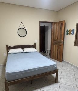a bedroom with a bed and a mirror on the wall at Casa Praia Los Remos Guarapari-Enseada in Guarapari