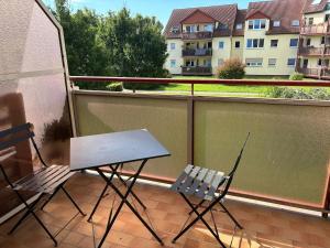 two chairs and a table on a balcony at Gemütliche 2-Zimmerwohnung in Schönefeld