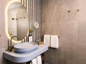 a bathroom with a sink and a mirror at voco Gosford by IHG in Gosford