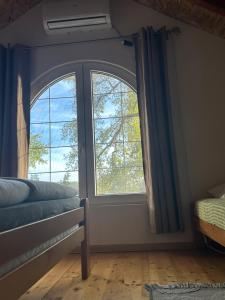a bedroom with two large windows and a bed at Dadula na Dunavu in Kovin