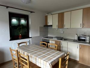 a kitchen with a table and chairs and a kitchen with a table and a table at Melisa's Holiday Home with pool tickets in Mostec